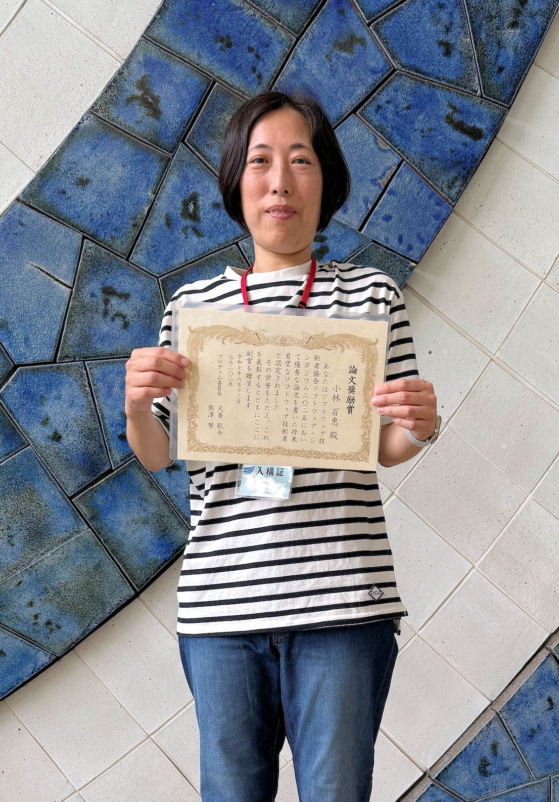 賞状を掲げる小林さんの写真